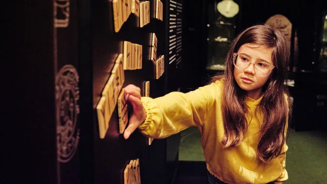 Child practices writing with runes.