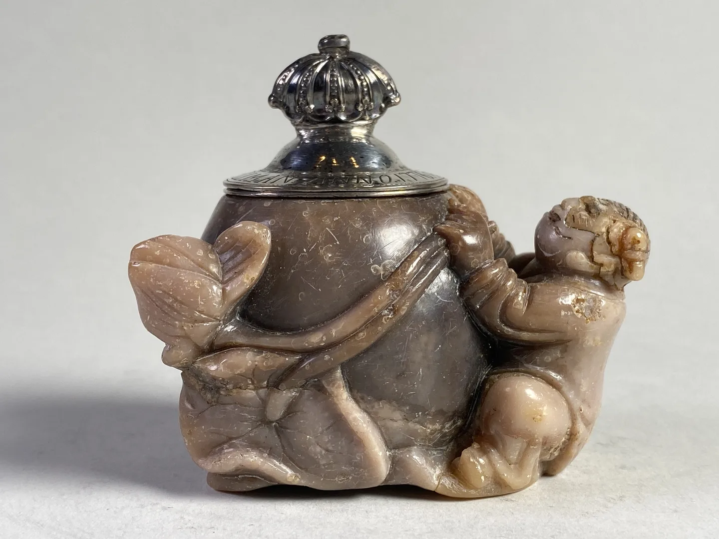Inkwell featuring a human figure intertwined with a lotus flower. 