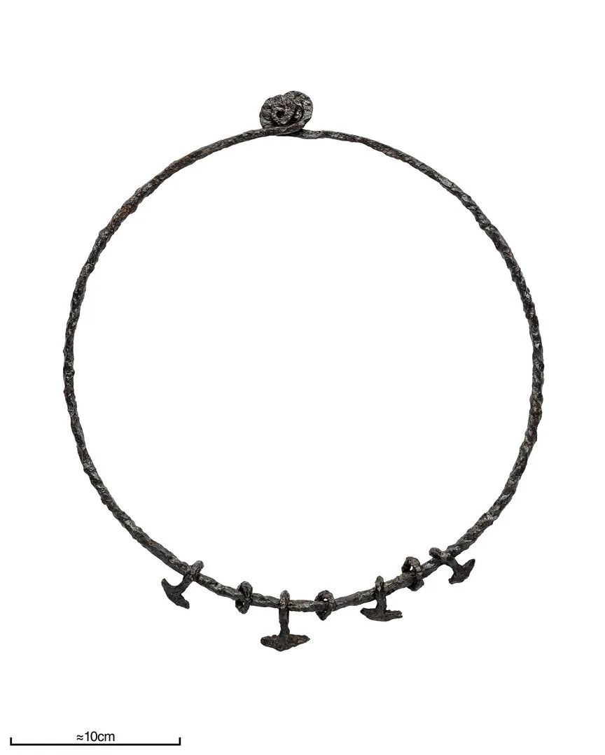 A metal ring with four hammer shaped pendants and three smaller rings.