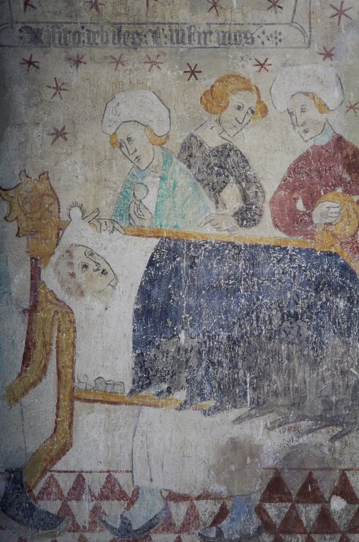 A man lying in bed with a doctor and two women standing by his side.