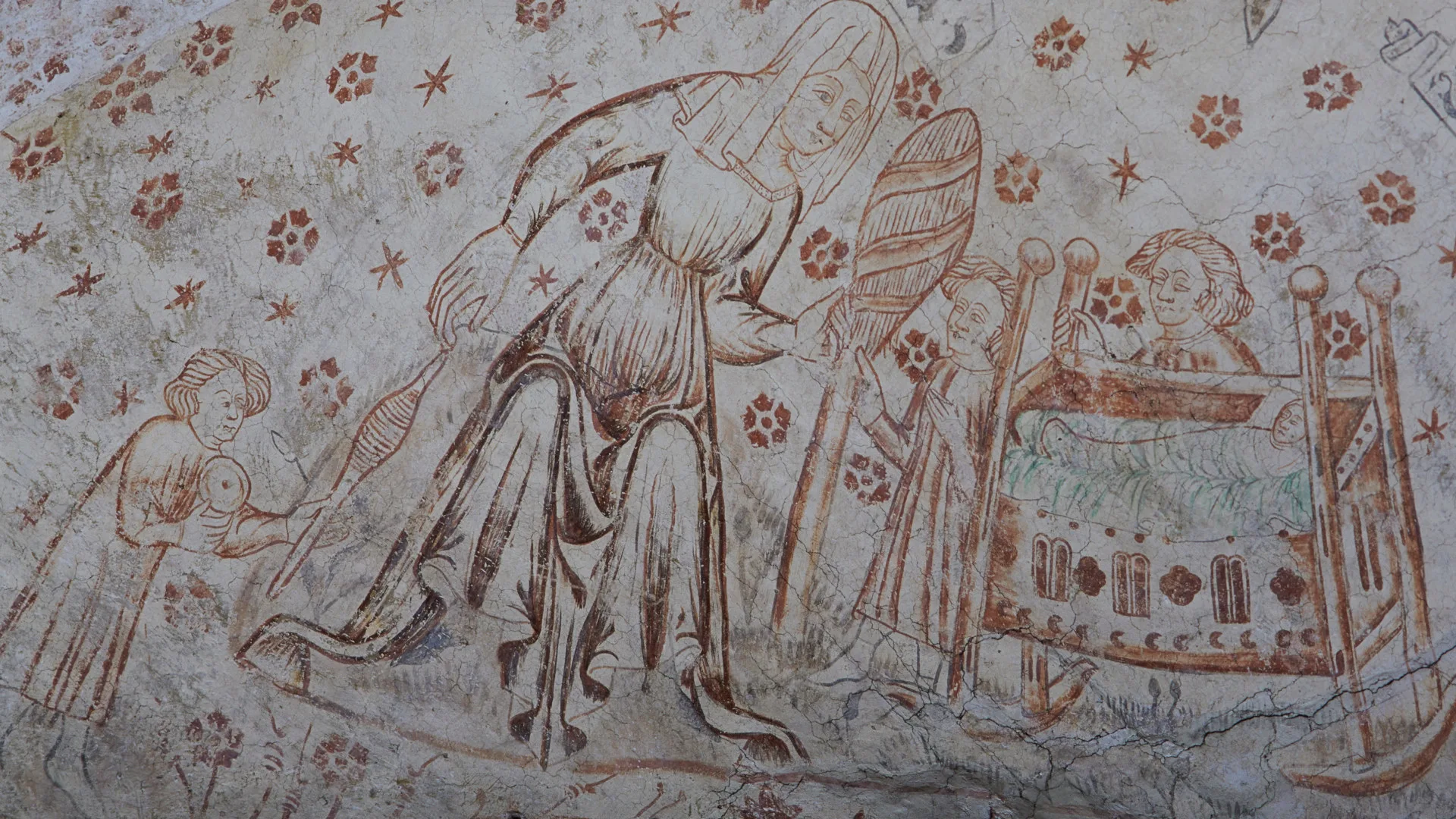 A woman in a long, wide dress and headcloth sitting by a spinning stand. Three older children nearby and a small infant in a cot.