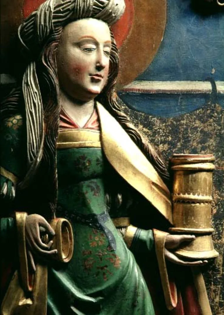 Colored wooden sculpture of a woman holding a cup