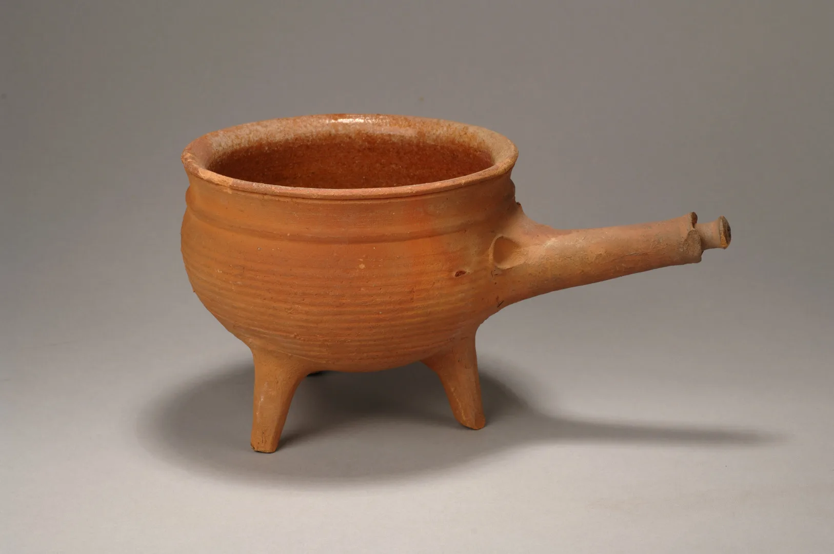 A three-legged ceramic pot