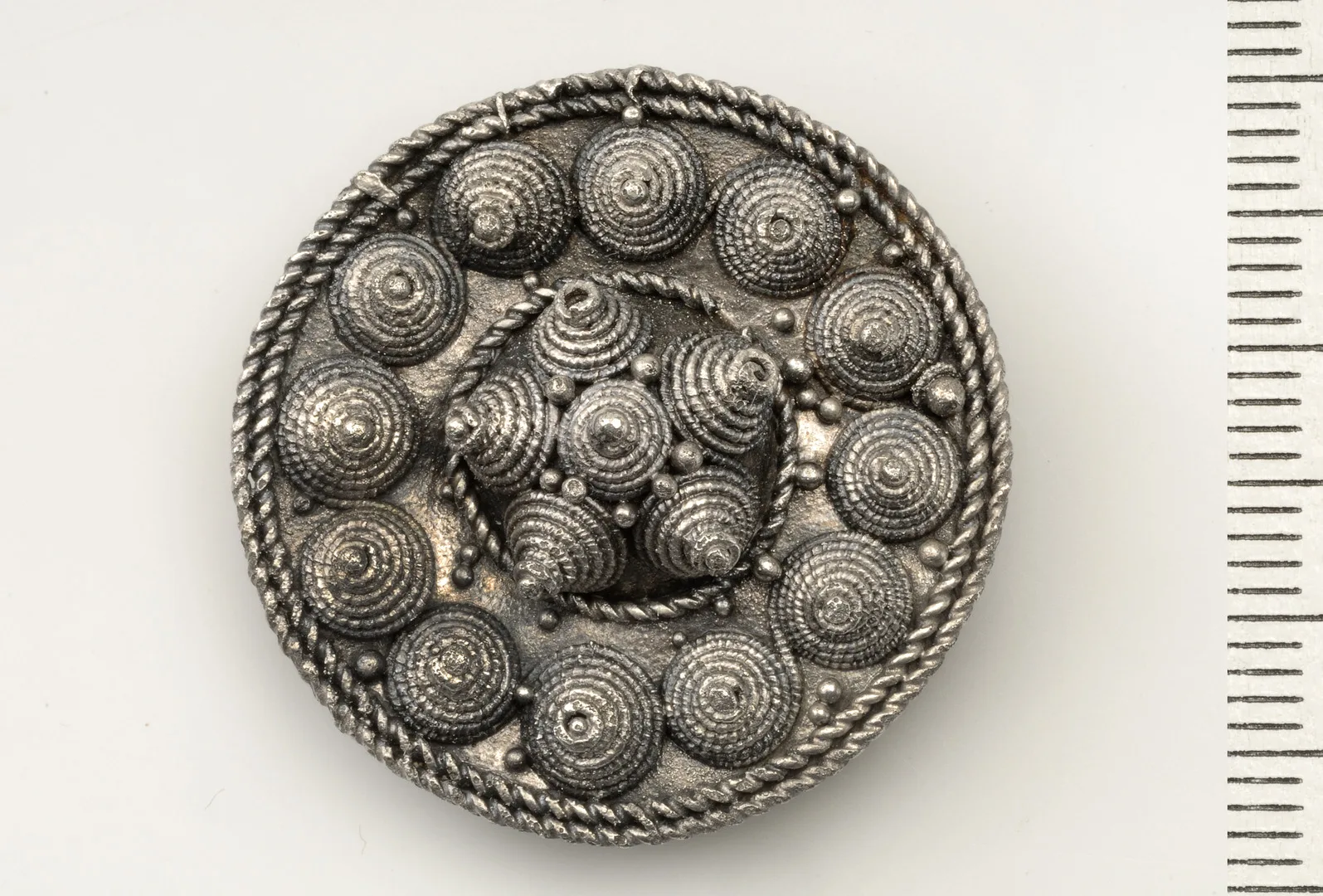 En rund brosch med cirkelformade dekorationer