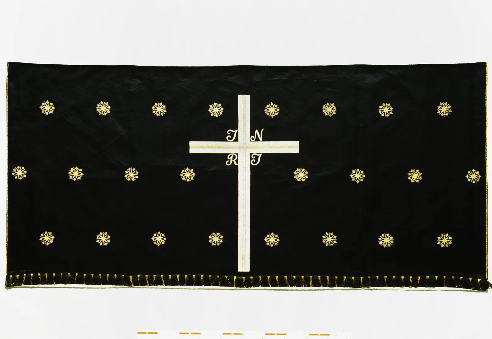 Black antependium, consisting of a large cross with initials INRI. On each side of the cross there are shimmering stars.