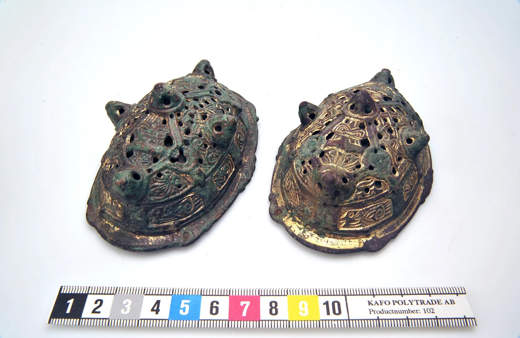 Oval spännen i brons, järn och guld