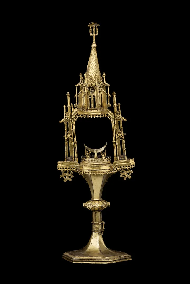 Gold object richly decorated with many details.