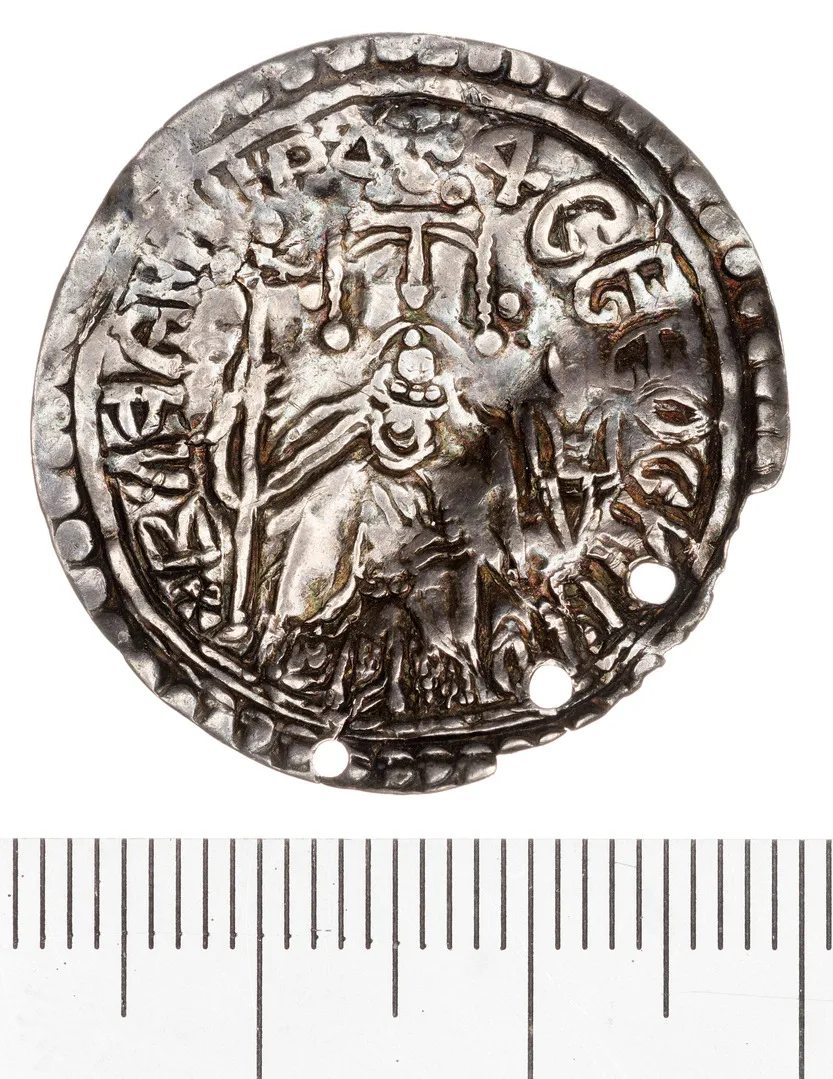 Silvermynt med tre små hål