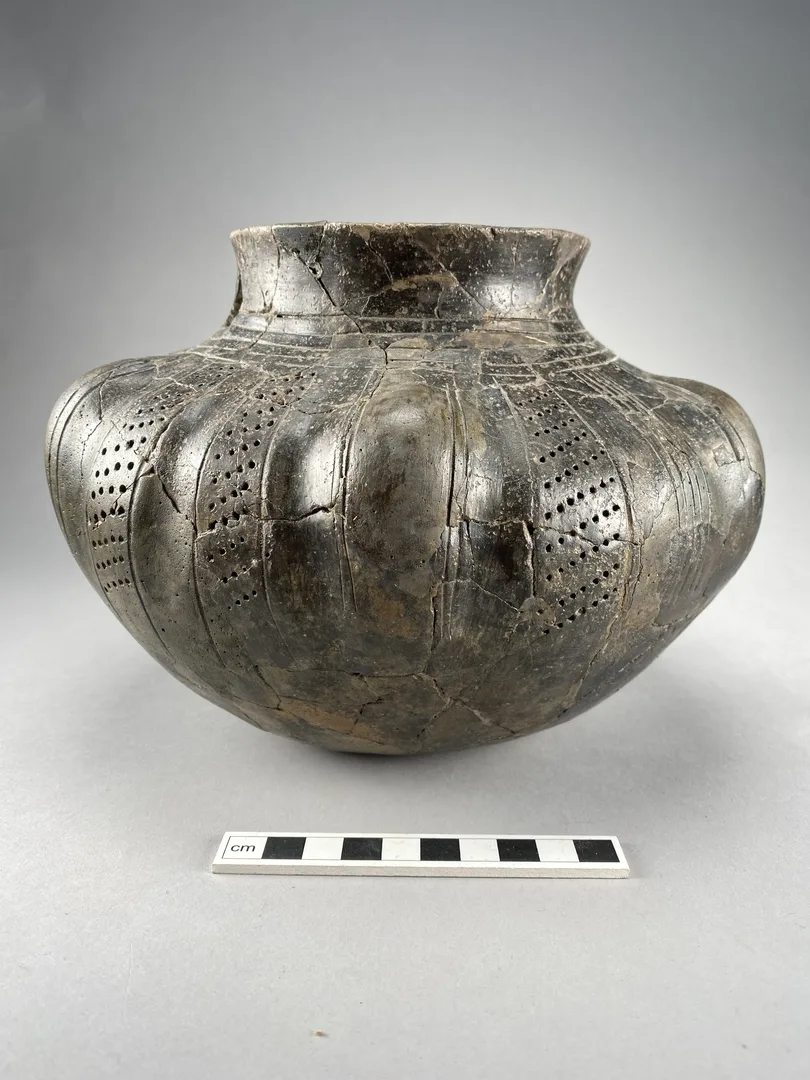 A buckel urn with lines and perforations