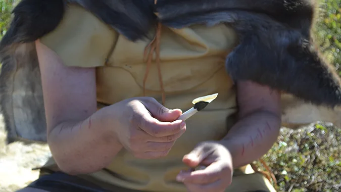 Person med pälsmantel håller tångspets