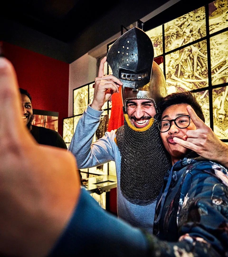 Two visitors lightly dressed with viking gear in the musuem laughing