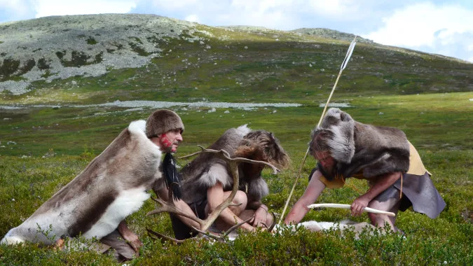Personer i pälskläder i ett naturlandskap