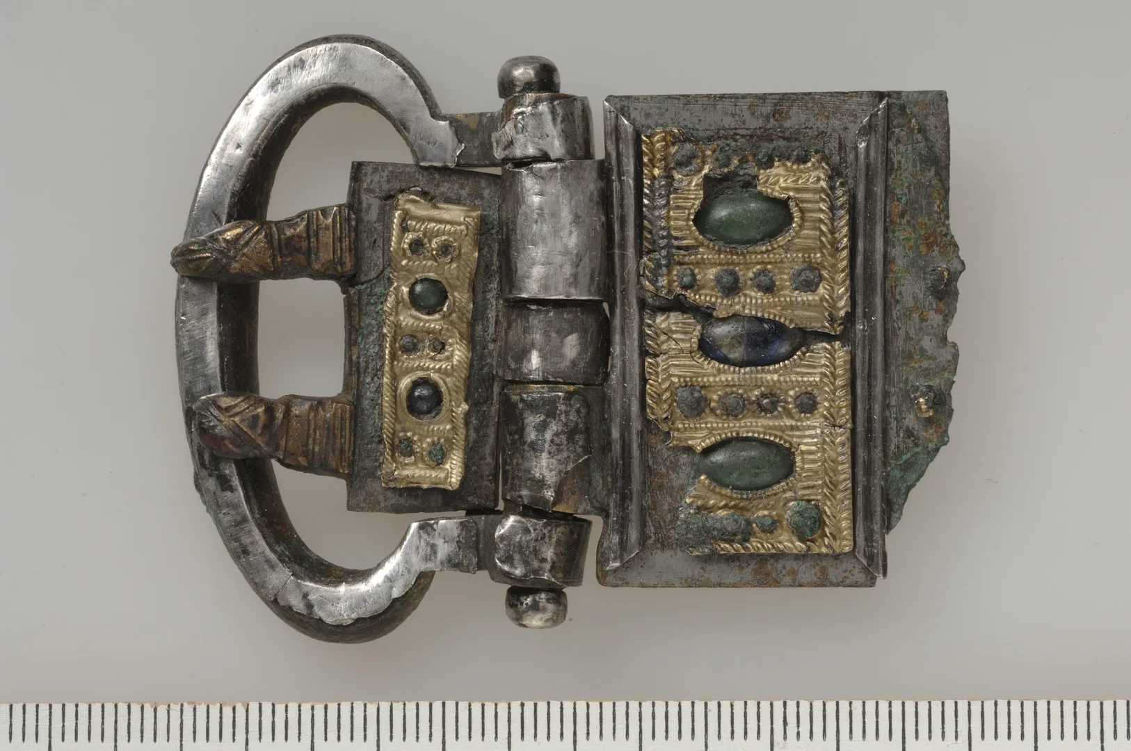 A robust buckle adorned with gemstones and gold