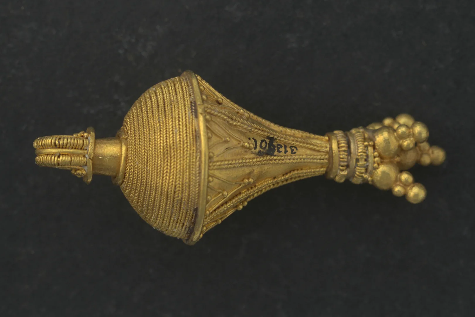 Detallj av en rikt ornerad guldberlock. 