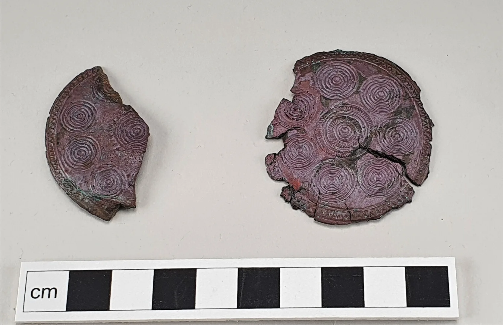 Fragment of two round bronze medallions with circular decor
