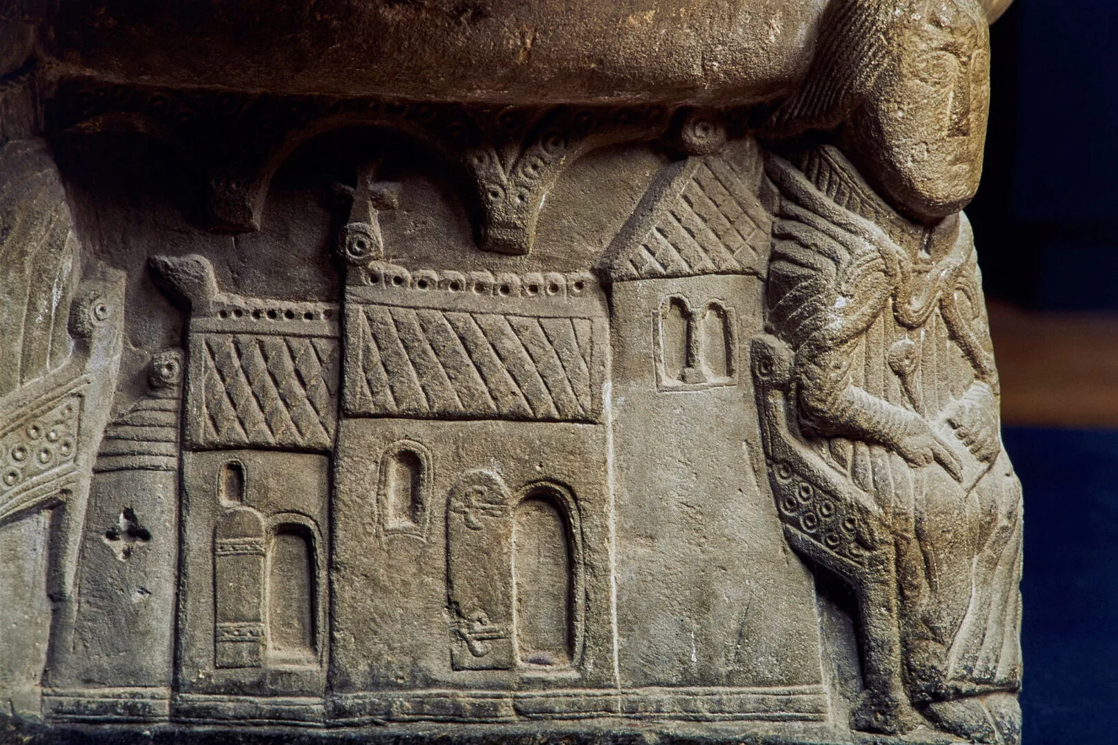 Bottendel av dopfunt med en bild av en kyrka med romansk arkitektur