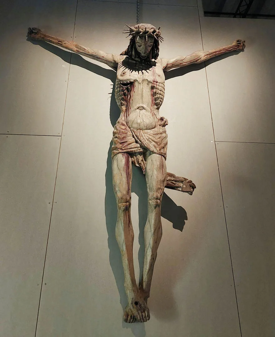 Träskulptur med Jesus på korset som blöder från sina sår