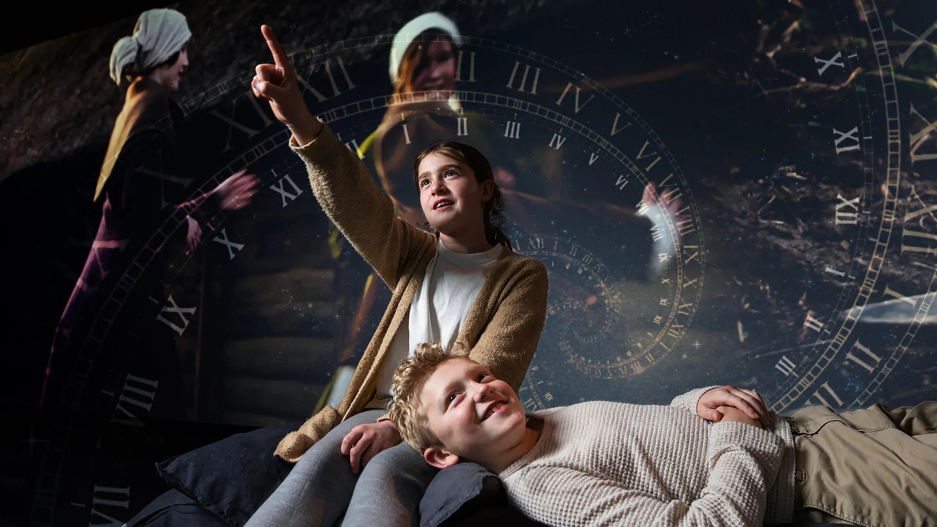 Barn ser en film i en utställning.