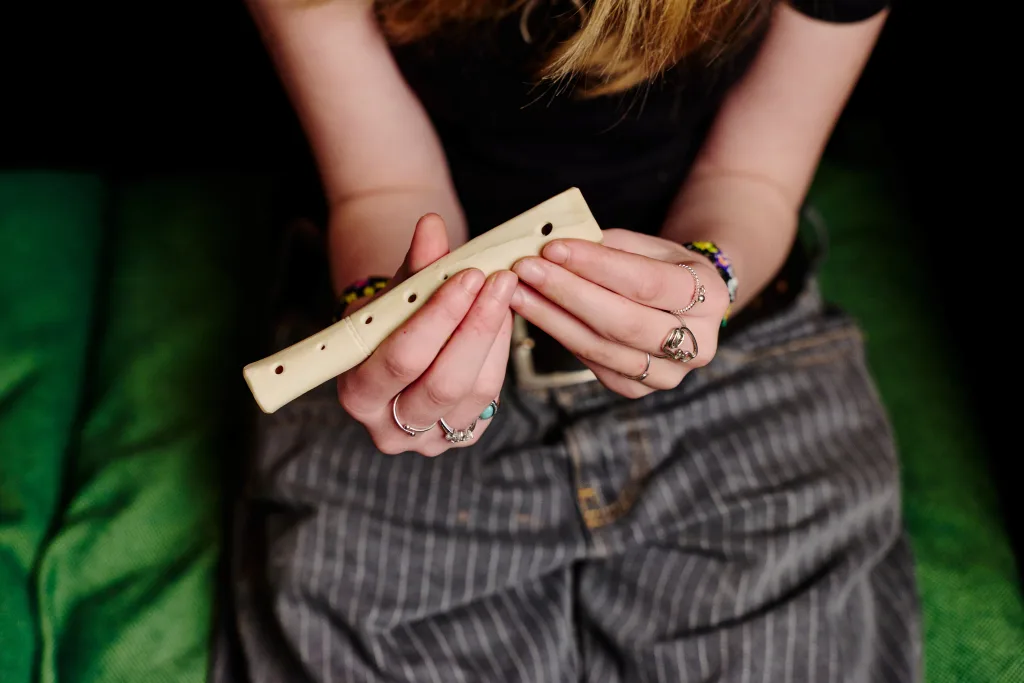 Skolelev håller i ett avlångt föremål med flertalet hål i 