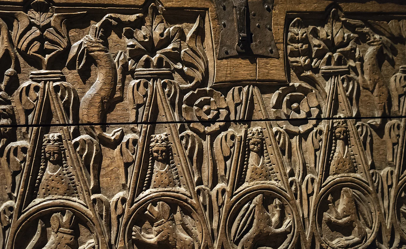 Surface in wood with carved figures