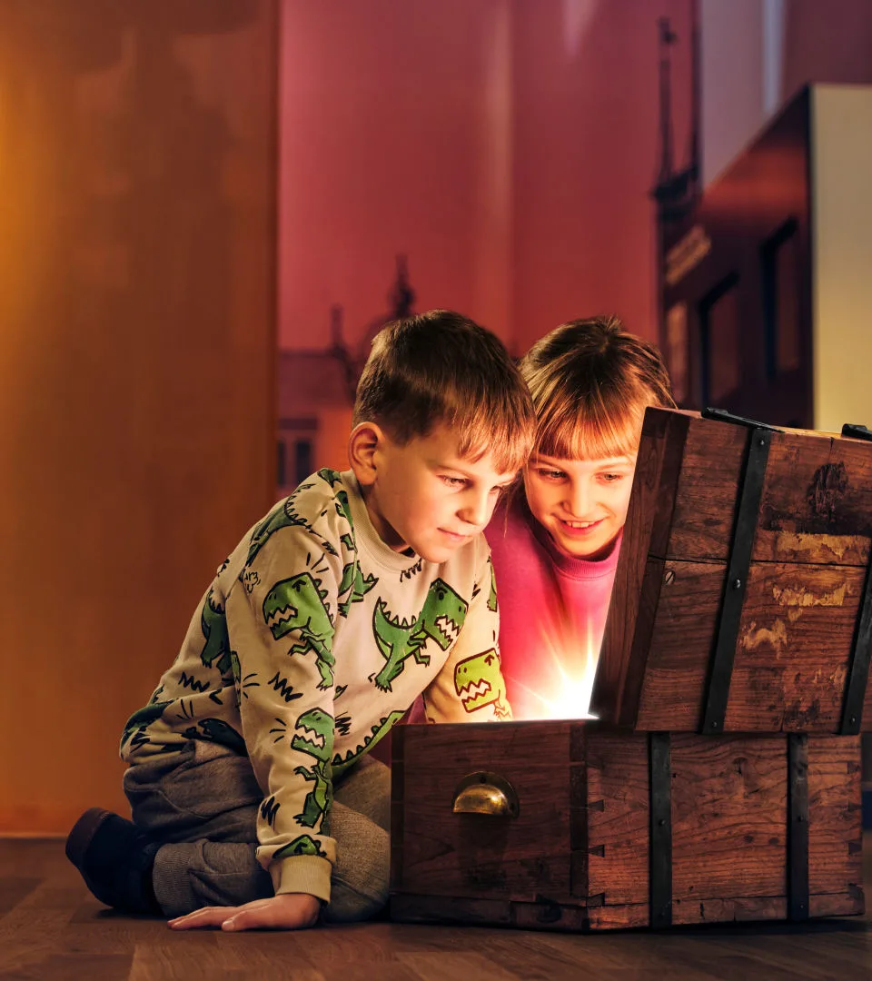 Två barn tittar in i en glänsande skattkista