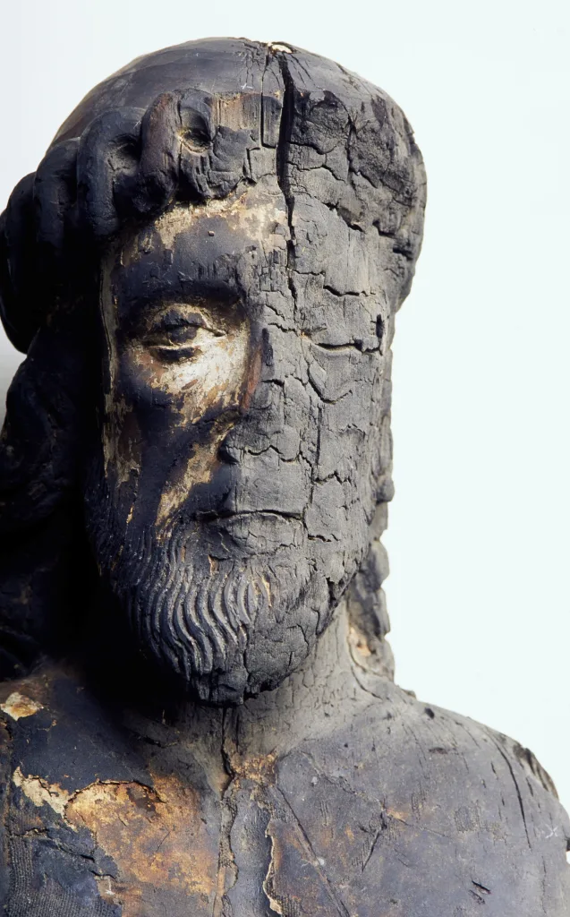 Träskulptur med bränt ansikte