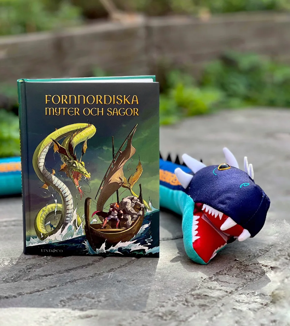 En bok om nordiska sagor omsluten av en leksaksdrake..
