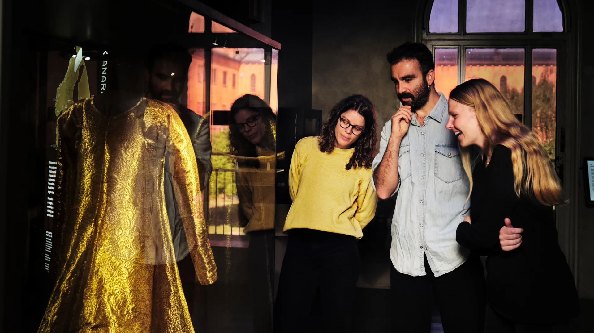 Vuxna tittar på en guldklänning på Historiska museet