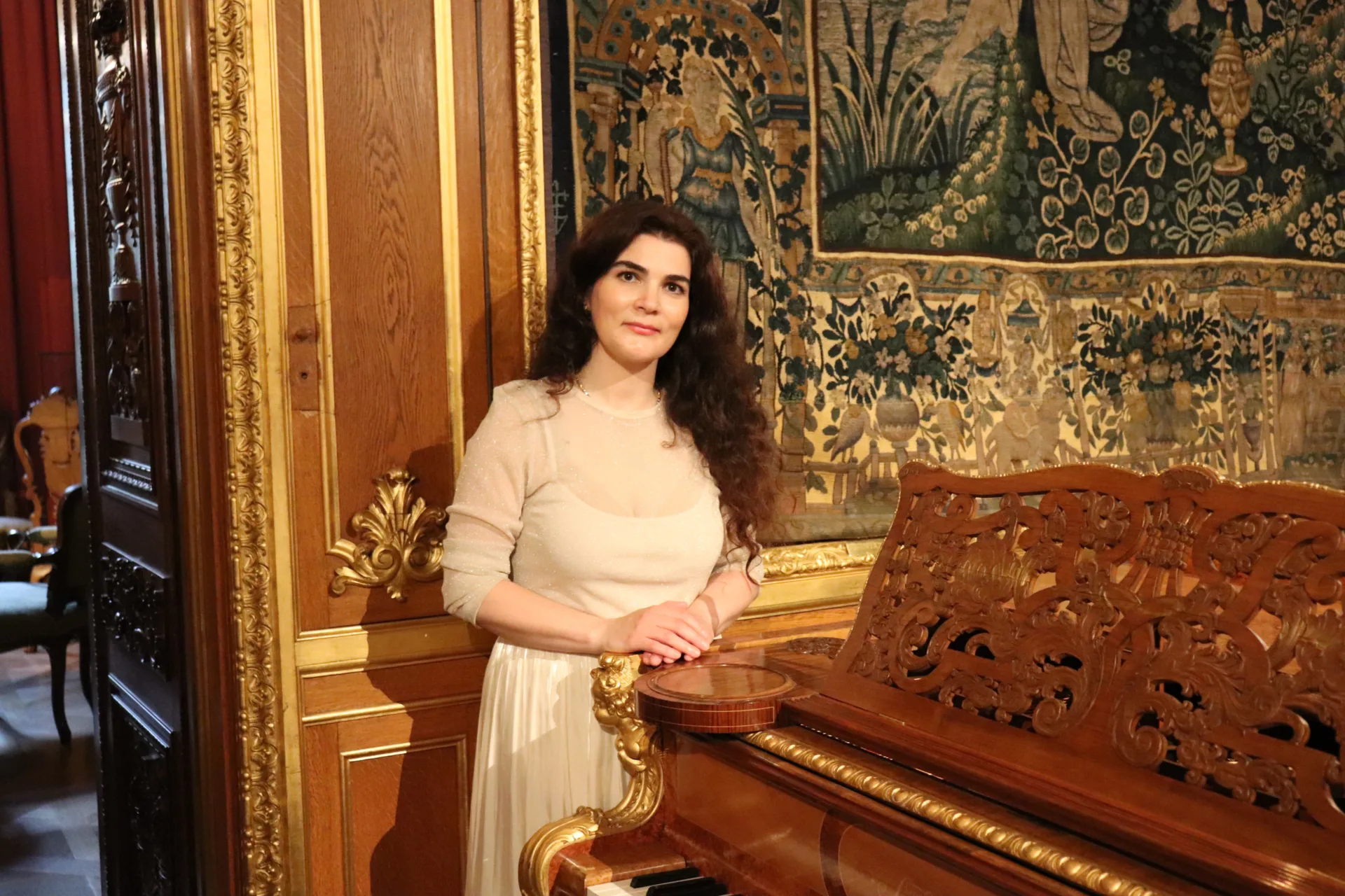 En person står vid ett piano.