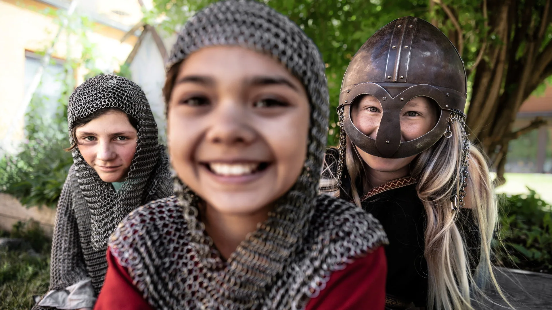 Tre barn står utklädda i vikingatida kläder.