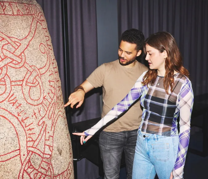 People exploring a rune stone